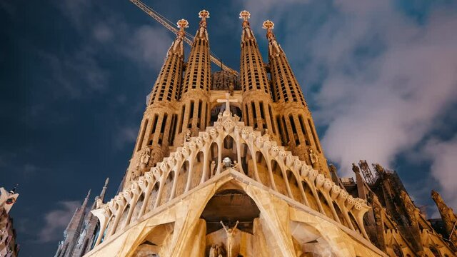 Night timelapse of Gaudi's masterpiece - Sagrada Familia Basilica. UNESCO world heritage. View of outdoor interior, Impressive facade.