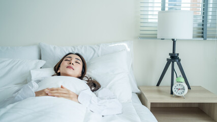 Asian beautiful comfort girl in pajamas get up from sleep in bedroom.
