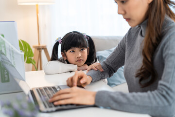 Asian young kid daughter feeling sad and need to play with busy mother