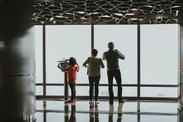 Fotobehang Burj Khalifa Family using a digital electronic telescope of the Burj Khalifa at the observation deck
