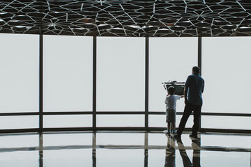 Family using a digital electronic telescope of the Burj Khalifa at the observation deck