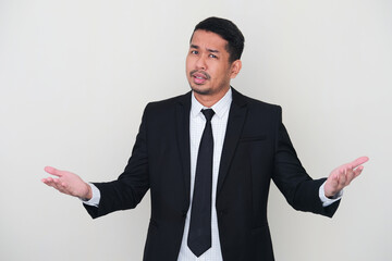 Adult Asian man wearing black suit and tie showing confused gesture