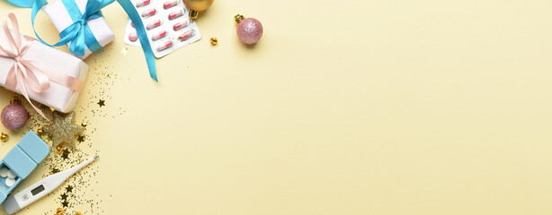 Pills, thermometer, gifts and Christmas decor on light background with space for text