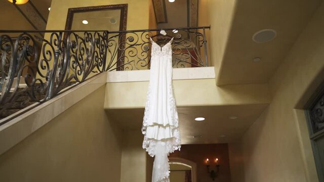 A wedding dress at the top of the stairs in a building.