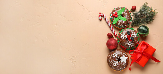 Tasty Christmas donuts and decorations and gift on light background with space for text