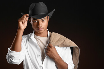 Handsome stylish African-American guy on dark background