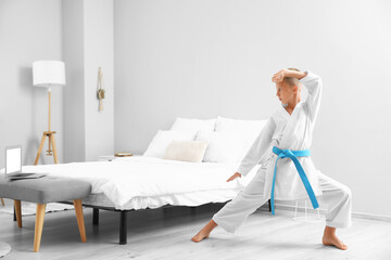 Little boy studying karate online at home © Pixel-Shot