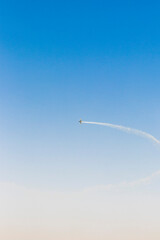 Military airplane performing stunts in clear blue sky. Airshow