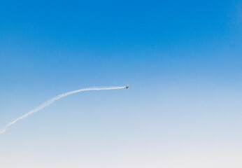 Military airplane performing stunts in clear blue sky. Airshow