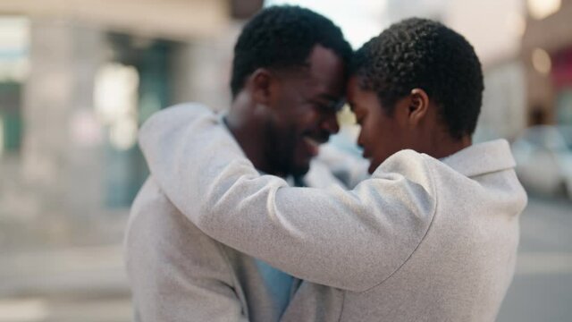 African american couple smiling confident hugging each other at street