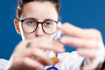 doctor ticks the needle of the vaccine syringe