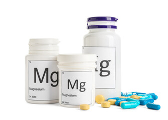 Different bottles with magnesium pills on white background
