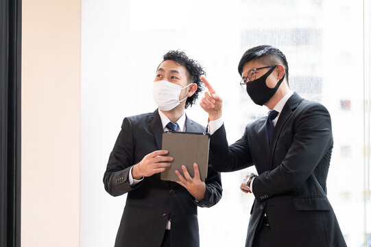 Executive Asian Businessmen Meeting By The Window, Copy Space Available, Masks Available.