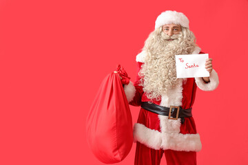Santa Claus with letter and bag on red background