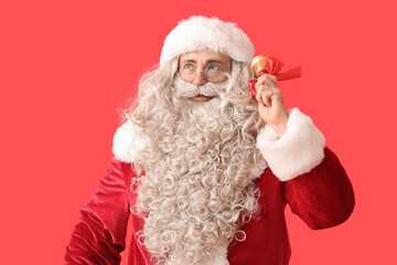 Fototapeta na wymiar Santa Claus with Christmas bell on red background