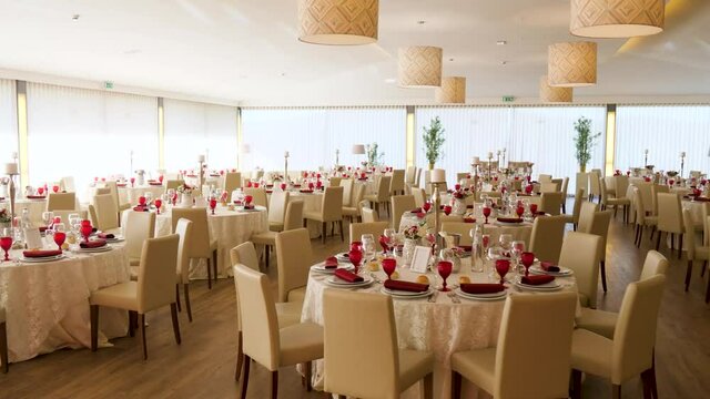 luxurious indoor wedding tables with flowers candles and chandeliers. Wedding venue saloon.