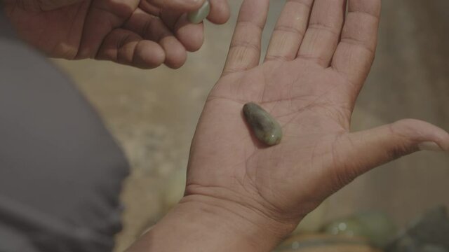Man looking a piece of raw jade in his hand. Jade market in China.