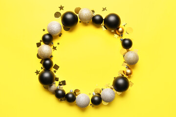 Frame made of beautiful Christmas balls and confetti on yellow background