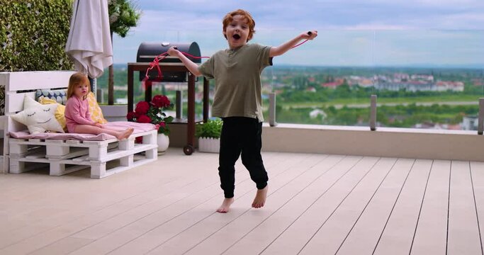 kids having fun on rooftop patio at summer evening, playing together at home