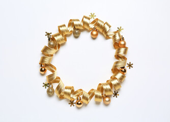 Frame made of golden ribbon and Christmas balls on white background
