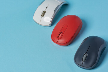 Red wireless mouse on blue background. Computer mouse.