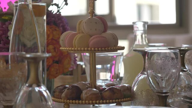 Sweet table with macarons and chocolate cake pops. Colorful macaroons on a two tier serving tray served on the table at an occasion.