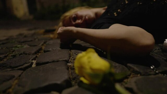 dead woman on the street - yellow flower on the ground with her wallet
