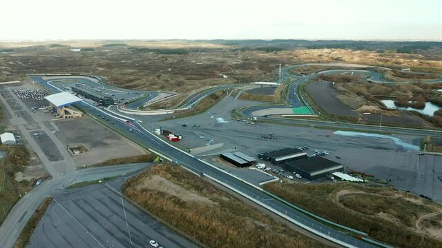 Formula One Cars Racing Down The Long Racing Track Road At Circuit Zandvoort In Netherlands. - Aerial