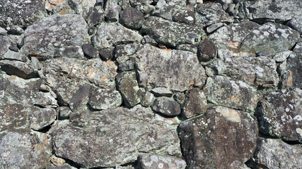 The texture of big real rock stone wall old and dirty on japan Himeji castle in sunny summer day.