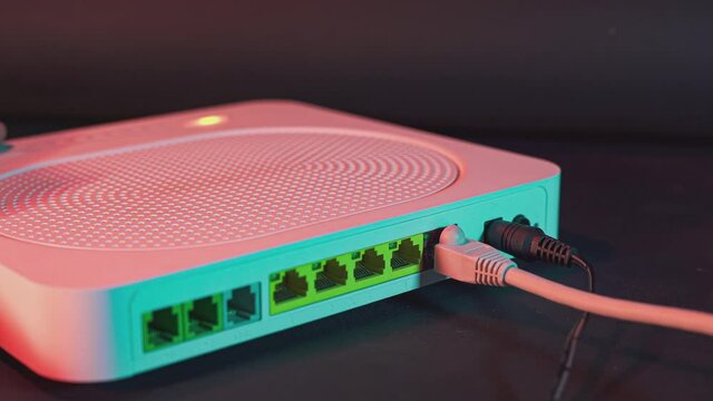 Shot showing the ethernet cable on the back of the internet router. A shot showing high-speed wired or wireless internet. 5g internet