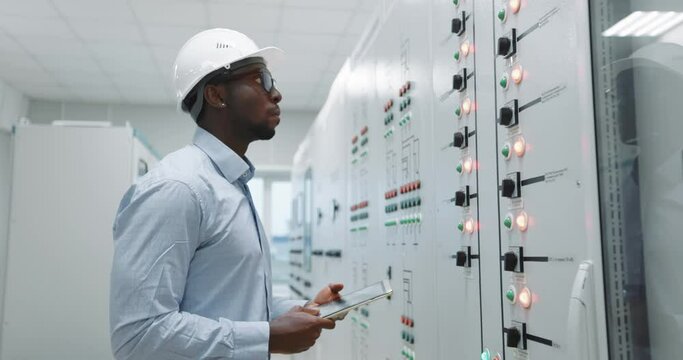Portrait of an engineer in a hard hat holding a tablet.