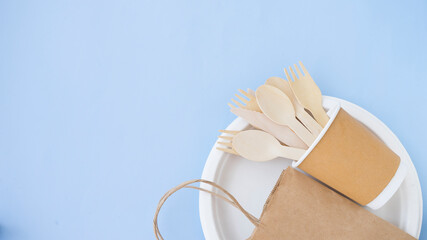Disposable eco-friendly tableware and packaging on a blue background