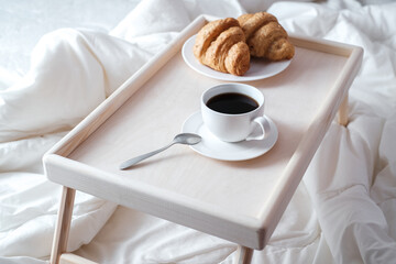 Breakfast on wooden table for bed. Coffee, cake and apple for healthy morning eating. 