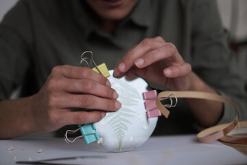 woman fixes glass plates. A picture of dried flowers. Master class on creating frame. be more...