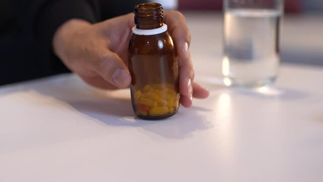 Suicide attempt, pills. The man who spills the pills on the table will commit suicide.