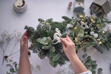 woman decorates a Christmas arrangement. Hands close-up. The new year celebration. Flower shop....