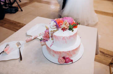 Pastel pink layer wedding cake decorated with white peony flowers