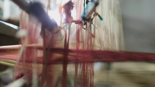 Close-up shot of the weaving process of the yarn or thread making for the use of mats in Sri Lanka weaving village.