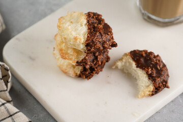 Several coconut flakes cookies dipped in chocolate on a white marble board, christmas decoration