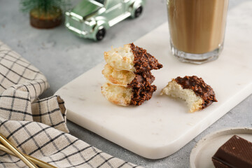 Several coconut flakes cookies dipped in chocolate on a white marble board, christmas decoration