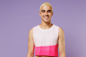 Young trendy blond hispanic latin gay man 20s with make up in fashionable bright pink top look camera isolated on plain pastel purple background studio portrait People lifestyle fashion lgbtq concept - obrazy, fototapety, plakaty