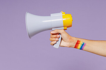Cropped close up photo shot of gay man male hand arm hold scream in megaphone coming out promo copy space mockup isolated on plain pastel purple color background studio portrait. Pride lgbtq concept.