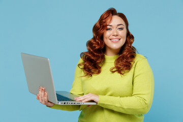 Young smiling happy chubby overweight plus size big fat fit woman wear green sweater hold use work...