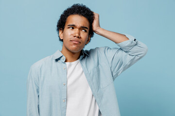 Confused preoccupied embarrassed sad young black curly man 20s years old wear white shirt look...