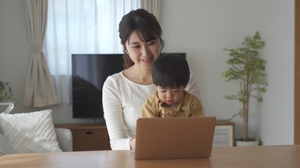 パソコン作業をする母親と息子