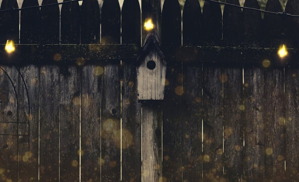 Closeup of the old wooden birdhouse on the fence.