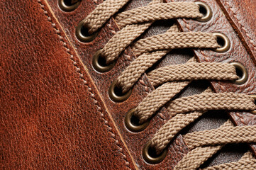 Shoe lace on brown leather - obrazy, fototapety, plakaty