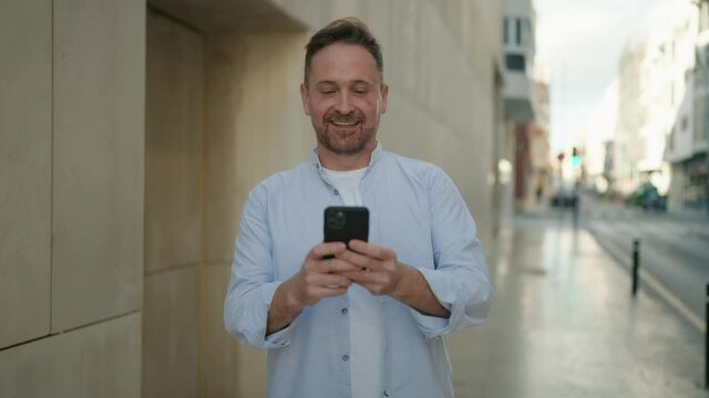 Young caucasian man smiling confident using smartphone at street
