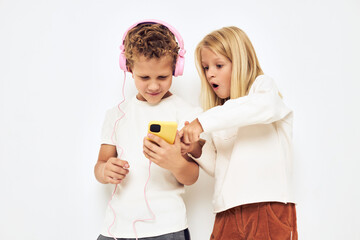 Young cheerful kid headphones with phone entertainment light background