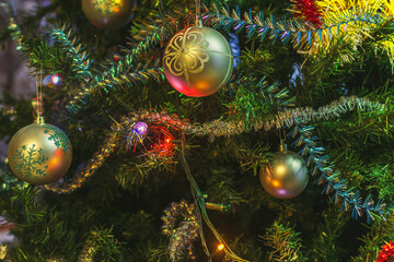 Obraz na płótnie Canvas Beautiful Christmas tree decorations: balls, tinsel, a luminous garland on a dark green background. Festive mood.
